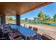 Covered patio area with tables and chairs overlooking a lush golf course and lake at 10410 E San Tan Blvd, Sun Lakes, AZ 85248