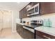 Modern kitchen featuring stainless steel appliances, granite countertops, and dark wood cabinetry at 10410 E San Tan Blvd, Sun Lakes, AZ 85248