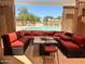 Relaxing outdoor seating area with a poolside view and cozy red cushions on wicker seating at 10410 E San Tan Blvd, Sun Lakes, AZ 85248