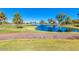 Scenic view of the community pond surrounded by lush green landscaping and a paved pathway at 10410 E San Tan Blvd, Sun Lakes, AZ 85248