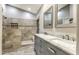 Bathroom featuring double vanity, marble counters, and tiled shower with built-in niche at 1086 S Western Skies Dr, Gilbert, AZ 85296