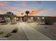 Charming desert landscaping accents this home with a sidewalk with lights leading to the front door at 10906 W Thunderbird Blvd, Sun City, AZ 85351