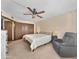 Spacious bedroom with ceiling fan, neutral carpet, and an ensuite bathroom at 10906 W Thunderbird Blvd, Sun City, AZ 85351