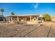 Expansive backyard featuring a covered patio, desert landscaping, and a rock garden at 11005 W Crestbrook Dr, Sun City, AZ 85351