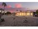 The backyard features desert landscaping with rocks, and a covered patio perfect for entertaining at 11005 W Crestbrook Dr, Sun City, AZ 85351