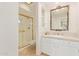 Cozy bathroom features a glass enclosed shower and vanity with decorative mirror at 11005 W Crestbrook Dr, Sun City, AZ 85351