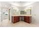 Double vanity bathroom featuring wood cabinets, ample counter space, and tiled floors at 11005 W Crestbrook Dr, Sun City, AZ 85351