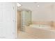 Modern bathroom showcases soaking tub and glass block shower, creating a spa-like retreat at 11005 W Crestbrook Dr, Sun City, AZ 85351