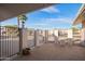 Wrought iron gates lead to a meticulously landscaped front yard under a bright blue, sunny sky at 11005 W Crestbrook Dr, Sun City, AZ 85351