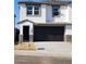 Modern two-story home featuring a dark garage door, white stucco, stone accents, and neat landscaping at 1111 E Mcneil St, Phoenix, AZ 85044