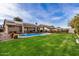 Expansive backyard featuring a well-manicured lawn, a refreshing pool, and an inviting covered patio at 13238 W Market St, Surprise, AZ 85374