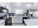 Contemporary kitchen featuring white cabinets, stainless appliances, quartz countertops, and black hardware at 13238 W Market St, Surprise, AZ 85374