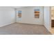 Bedroom featuring neutral carpet, white walls, and windows with views of the neighborhood at 1344 W Kennedy Ave, Coolidge, AZ 85128