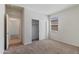 Well lit carpeted bedroom with window, open door to another room, and sliding closet door at 1344 W Kennedy Ave, Coolidge, AZ 85128