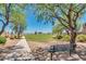 Park with a sidewalk leading to a green space area with lush green trees and a bench at 1344 W Kennedy Ave, Coolidge, AZ 85128