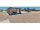 Outdoor community space with picnic tables under a shaded structure, with a playground in the background at 1344 W Kennedy Ave, Coolidge, AZ 85128