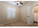 Bedroom features a ceiling fan, large window, closet and neutral color scheme at 1363 E Amberwood Dr, Phoenix, AZ 85048