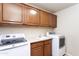 Laundry room showcasing a washer, a dryer, counter space, and wooden cabinets at 1363 E Amberwood Dr, Phoenix, AZ 85048