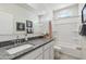 Bathroom showcasing a vanity with granite counters, a shower/tub combo, and a framed mirror at 1404 W Kennedy Ave, Coolidge, AZ 85128