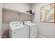 Bright laundry room with a Whirlpool washer and dryer set, shelf, and decor for functional convenience at 1404 W Kennedy Ave, Coolidge, AZ 85128