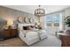 Bright main bedroom featuring a queen bed, stylish lighting fixture, and views through two windows at 1404 W Kennedy Ave, Coolidge, AZ 85128