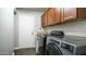 Laundry room featuring modern appliances, dark cabinets, and a side entrance at 14052 S 24Th Way, Phoenix, AZ 85048