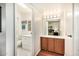 Bright bathroom with a large mirror, a white vanity, and a view of a bedroom through a mirror at 14209 N Palm Ridge Dr, Sun City, AZ 85351