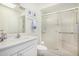 Well-lit bathroom features a shower with glass doors, white vanity, toilet and coordinating accessories at 14209 N Palm Ridge Dr, Sun City, AZ 85351