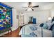 Bedroom showcasing hardwood floors, a colorful quilt, and a view into the bathroom and closet at 14209 N Palm Ridge Dr, Sun City, AZ 85351