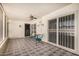 Screened in patio area featuring tiled floors and a ceiling fan, with seating for two at 14209 N Palm Ridge Dr, Sun City, AZ 85351