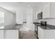 The kitchen features modern stainless steel appliances, a granite island, and bright white cabinets at 1432 W Hess Ave, Coolidge, AZ 85128