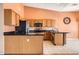 Traditional kitchen featuring light wood cabinetry, black countertops, and stainless steel appliances at 14410 N Silverado Dr, Fountain Hills, AZ 85268