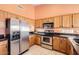 Kitchen with tile floors, stainless steel appliances, and solid wood cabinets at 14410 N Silverado Dr, Fountain Hills, AZ 85268