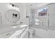 Well-lit bathroom featuring a framed mirror, shower-tub combo, and elegant white cabinetry at 1523 E Treasure Cove Dr, Gilbert, AZ 85234