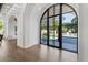 Bright, airy foyer with hardwood floors, arched doorways, and a large window looking out onto a verdant lawn at 1523 E Treasure Cove Dr, Gilbert, AZ 85234