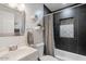 Modern bathroom with a shower-tub combo with dark tile and a decorative shower curtain at 1635 W Grovers Ave, Phoenix, AZ 85023