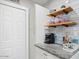 Modern kitchen featuring floating wooden shelves, granite counters, and sleek appliances at 1635 W Grovers Ave, Phoenix, AZ 85023