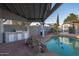 Covered outdoor kitchen area featuring a built-in grill and mini fridge near the refreshing pool at 1635 W Grovers Ave, Phoenix, AZ 85023