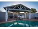 A cozy covered poolside outdoor kitchen with a stone waterfall creates a tranquil atmosphere at 1635 W Grovers Ave, Phoenix, AZ 85023