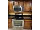 A close-up of the kitchen's stainless steel microwave and stovetop, complemented by dark wood cabinetry at 1750 W Union Hills Dr # 91, Phoenix, AZ 85027