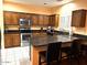 Spacious kitchen with wood cabinets, dark countertops, stainless steel appliances, and a convenient center island with seating at 1750 W Union Hills Dr # 91, Phoenix, AZ 85027