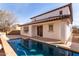 Backyard with a sparkling pool that reflects the home's architecture under a blue sky at 18268 W Carol Ave, Waddell, AZ 85355