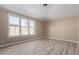 Bedroom featuring vinyl flooring, neutral paint, bright windows, and outlets along the baseboards at 18268 W Carol Ave, Waddell, AZ 85355