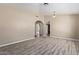 Open-concept living room showcasing vinyl flooring, neutral paint, and archways to other spaces at 18268 W Carol Ave, Waddell, AZ 85355