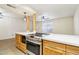 Kitchen island with white countertop, pendant lighting, oven, and adjacent to open living space at 2117 W Pontiac Dr, Phoenix, AZ 85027