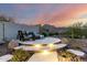 Outdoor seating area with uplighting, stone details, and sunset views of the mountains at 21186 W Hillcrest Blvd, Buckeye, AZ 85396