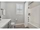 Bright bathroom with a shower-tub combo, white shower curtain, and gray vanity with modern fixtures at 21186 W Hillcrest Blvd, Buckeye, AZ 85396