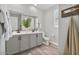 Bright bathroom with double vanity, decorative plants, modern mirrors and lighting, and wood-look tile flooring at 21186 W Hillcrest Blvd, Buckeye, AZ 85396