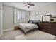 Bedroom featuring neutral walls, wood ceiling fan, dark colored furniture, and a decorative rug at 21186 W Hillcrest Blvd, Buckeye, AZ 85396