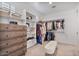 Walk-in closet with custom built-in shelves, hanging racks, drawers, with neutral carpeting at 21186 W Hillcrest Blvd, Buckeye, AZ 85396